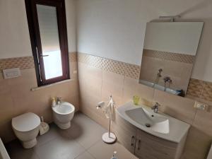 a bathroom with a sink toilet and a mirror at Pepe's house , a 1 km dal mare in Isca sullo Ionio