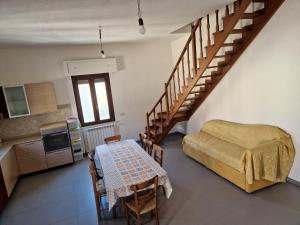 a room with a bed and a table and a staircase at Pepe's house , a 1 km dal mare in Isca sullo Ionio
