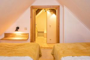 a bedroom with two beds and a mirror at Kellerstöckl Postrumer Weinberg 48 in Kulm im Burgenland