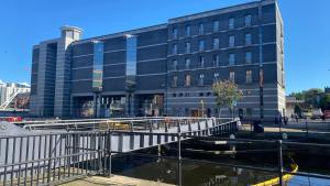 a bridge over a river in front of a building at Lovely City Centre 1 bed apartment in Beeston Hill
