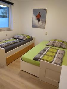 - 2 lits jumeaux dans une chambre avec une photo sur le mur dans l'établissement Ferienwohnung J10, Playmobil Funpark Zirndorf Nürnberg, à Zirndorf