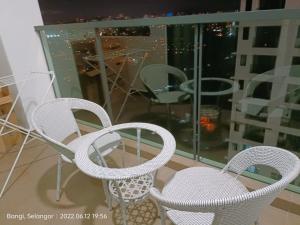 three white chairs and a table on a balcony at Sri Kejora Vista Bangi Homestay -Studio in Kajang