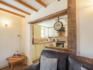 a living room with a couch and a clock on the wall at The Dairy - Uk37518 in Routh