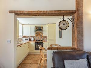 a kitchen with a table and a clock on the wall at The Dairy - Uk37518 in Routh