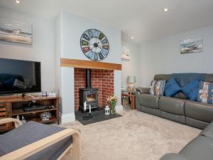 a living room with a fireplace and a clock on the wall at Coastal Haven in Dawlish