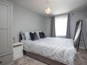 a bedroom with a bed and a window at Coastal Haven in Dawlish