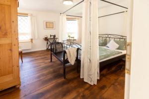 a bedroom with a canopy bed and a wooden floor at Am Bärenbrunnen in Bernkastel-Kues