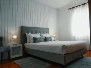 a bedroom with a large bed with two lamps at Orchid House Madeira in Calheta