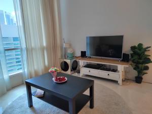 een woonkamer met een tv en een salontafel bij Inspired Homes @ KLCC Soho Suite in Kuala Lumpur