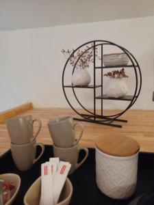 uma mesa com três chávenas de chá e uma prateleira em Luxe-kamer Bed en Bokes 