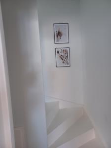 um chuveiro branco com duas imagens na parede em Luxe-kamer Bed en Bokes 