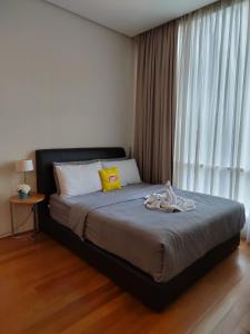 een slaapkamer met een groot bed met een raam bij Inspired Homes @ KLCC Soho Suite in Kuala Lumpur