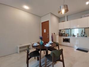 een keuken en eetkamer met een tafel en stoelen bij Inspired Homes @ KLCC Soho Suite in Kuala Lumpur