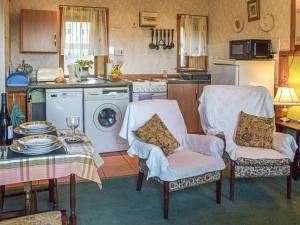 a kitchen with two chairs and a table and a stove at The Bothy - Uk37414 in Bunessan