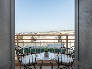 balcón con mesa y sillas y vistas a la playa en Elia Bettolo Hotel en La Canea