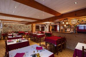 um restaurante com mesas e cadeiras e um bar em Logis Hôtel Restaurant L'ancienne Auberge em Bolquere Pyrenees 2000