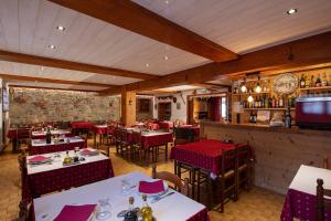 een restaurant met tafels en stoelen en een bar bij Logis Hôtel Restaurant L'ancienne Auberge in Bolquere Pyrenees 2000