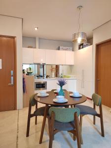 een keuken en eetkamer met een houten tafel en stoelen bij Inspired Homes @ KLCC Soho Suite in Kuala Lumpur