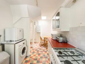 a kitchen with a washing machine and a stove at Inverwick Cottage in Nairn
