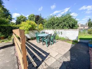a patio with a table and chairs in a backyard at Inverwick Cottage in Nairn
