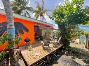 an orange house with a wooden deck in front of it at BUNGALOWS LES VAGUES ABONDES in Sainte-Anne