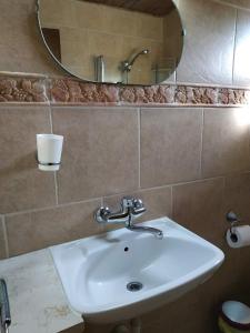 La salle de bains est pourvue d'un lavabo et d'un miroir. dans l'établissement beit nofesh waiss, à Bet Hillel