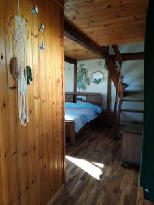 a bedroom with a bed and a wooden wall at beit nofesh waiss in Beit Hillel