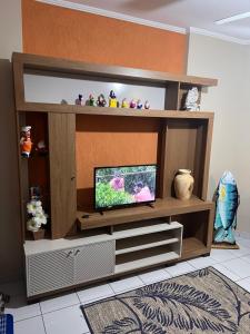 a wooden entertainment center with a flat screen tv at Residencial Michelângelo in Mongaguá