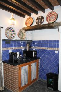 uma cozinha com azulejos azuis na parede e pratos na parede em Casa Dom Dinis em Monsaraz