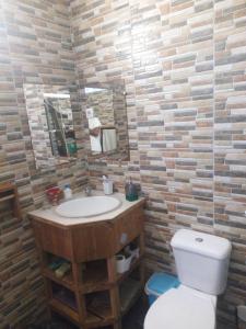 a bathroom with a sink and a toilet and a mirror at Appart Chris Mindelo in Mindelo