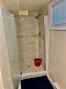 une douche avec un seau rouge dans une cabine de douche dans l'établissement Z & Z Apartment 2, à Newark