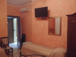 1 dormitorio con 1 cama y TV en la pared en PARADISE HOUSE, en Calatabiano