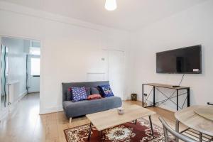 a living room with a couch and a flat screen tv at Impeccable and welcoming 3-Bed House in London in London