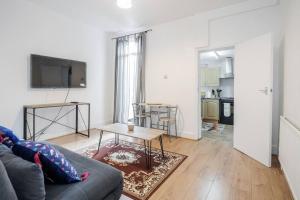 a living room with a couch and a table at Impeccable and welcoming 3-Bed House in London in London