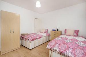 a bedroom with two beds and a dresser at Impeccable and welcoming 3-Bed House in London in London