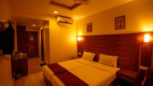 a bedroom with a large bed with a wooden headboard at National Residency in Mysore