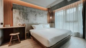 a bedroom with a large white bed and a window at The Cara Boutique Hotel in Kota Kinabalu