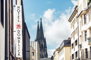 un campanario de iglesia en el fondo de una ciudad en Hotel Domblick Garni en Colonia