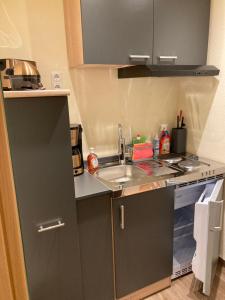 eine kleine Küche mit einer Spüle und einer Theke in der Unterkunft Hotel Falk in Bremen