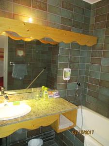 ein Badezimmer mit einem Waschbecken, einem Spiegel und einer Badewanne in der Unterkunft Apartment in Font-Romeu, near ski elevators in Font Romeu Odeillo Via
