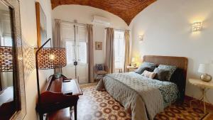 um quarto com uma cama e um candeeiro em Casa Victoria em Olhão