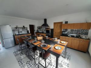 cocina con mesa larga con sillas y nevera en Rozéliande, en Roz-sur-Couesnon