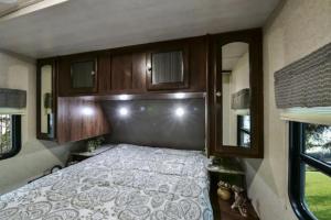 a bedroom with a bed in an rv at Heartland North Trail 31' RV in Manchaca