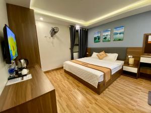 um quarto de hotel com uma cama e uma televisão de ecrã plano em New Sky Airport Hotel em Noi Bai