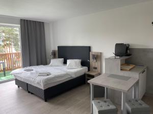 Schlafzimmer mit einem Bett, einem TV und einem Tisch in der Unterkunft Apartmán Kapy Lipno in Lipno nad Vltavou