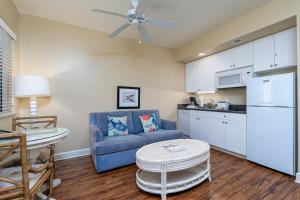 a living room with a blue couch and a kitchen at Harbour House at the Inn 313 in Fort Myers Beach