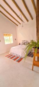 ein weißes Schlafzimmer mit einem Bett und einem Fenster in der Unterkunft Retiro da Irá in Corumbau