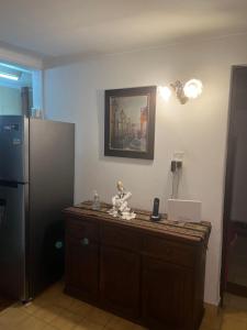 a kitchen with a counter with a refrigerator at Casa Bonita Barrio Sur in Santa Fe