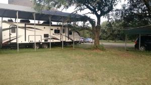 a white rv parked next to a building at Heartland North Trail 31' RV in Manchaca