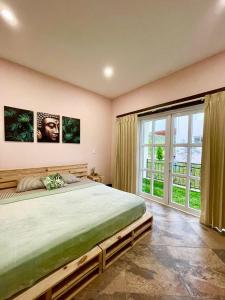 a bedroom with a large bed and a large window at Airb nb private rooms close to the airport Juan Santa María in Alajuela City